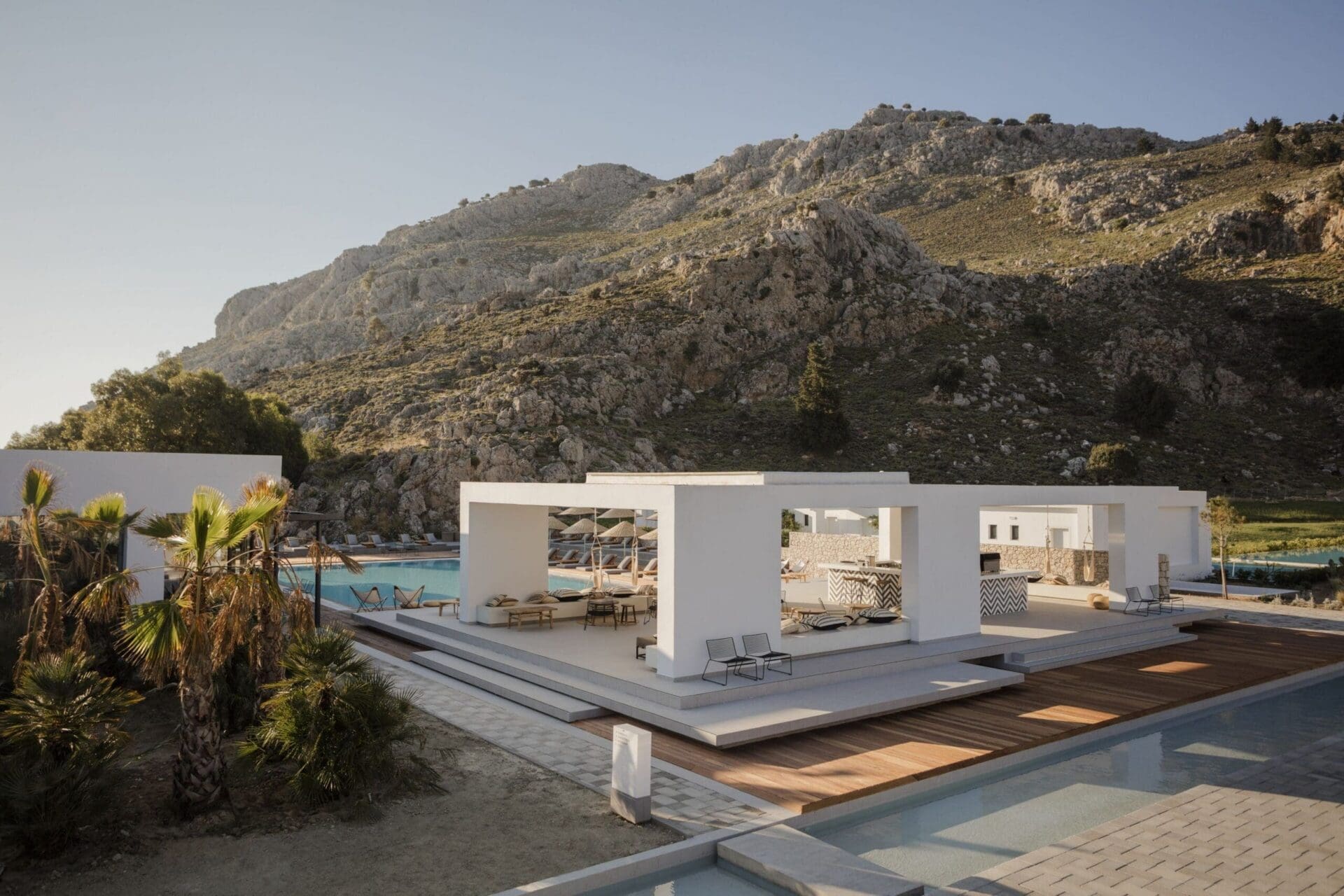 Casa Cook Rhodes — bohemian pool terrace with natural materials and sun loungers